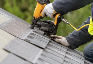 Workers nailing down roofing.